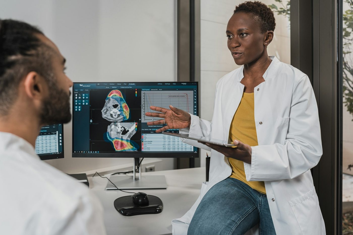 Two specialists reviewing a patient's scans and treatment plan together